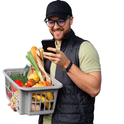 Homem segurando cesta de mercado com vários produtos, enquanto olha o saldo do UrbiPay no smartphone.